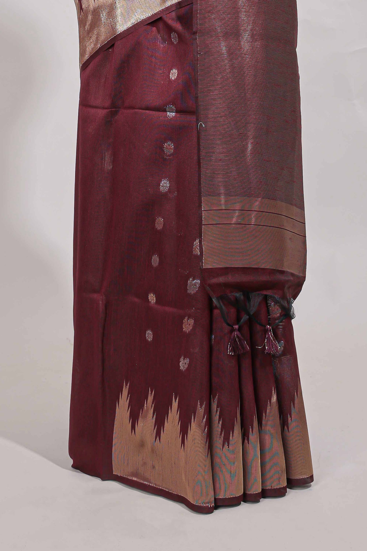 Maroon shimmering zari tussar saree with zari detailing temple pattern borders , and a rich zari pallu