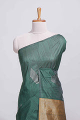 Bottle green tussar saree with subtle silver woven motifs paired with a rich antique gold zari pallu with tassels with contrast blouse piece