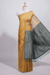 Mustard yellow tussar saree with subtle silver woven motifs paired with a rich zari pallu with tassels with contrast blouse piece