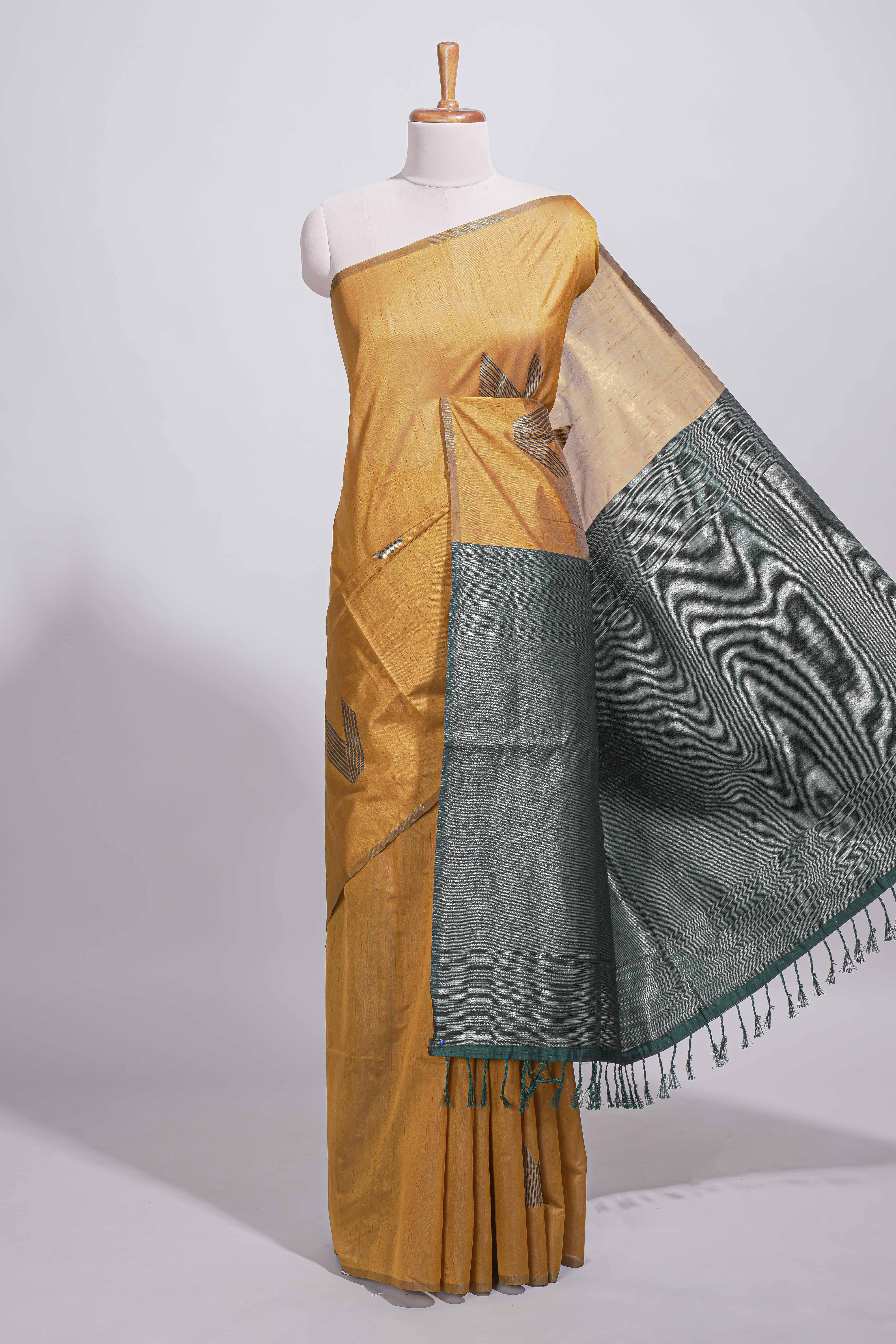 Mustard yellow tussar saree with subtle silver woven motifs paired with a rich zari pallu with tassels with contrast blouse piece