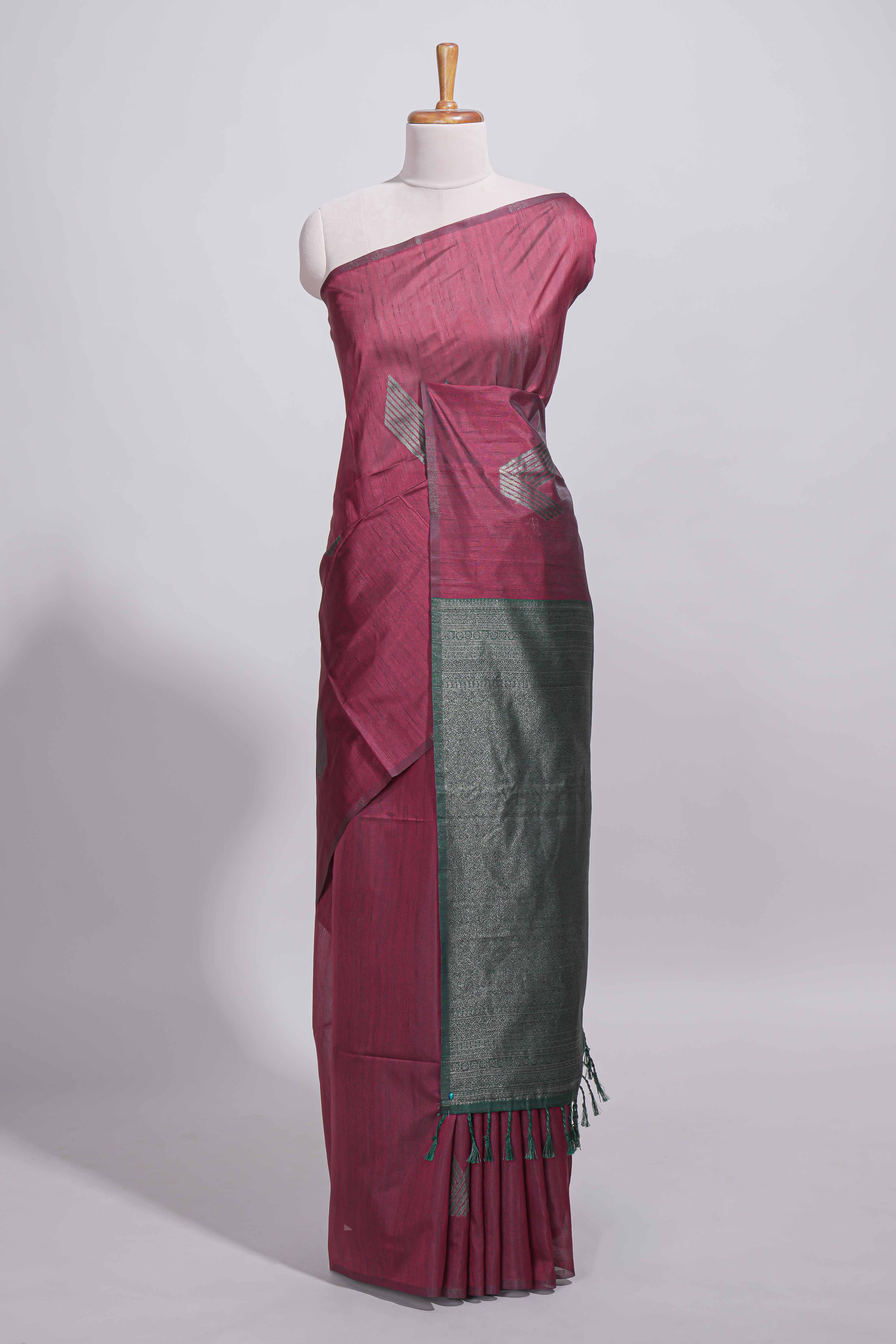 Maroon tussar saree with subtle silver woven motifs paired with a rich zari pallu with tassels with contrast blouse piece