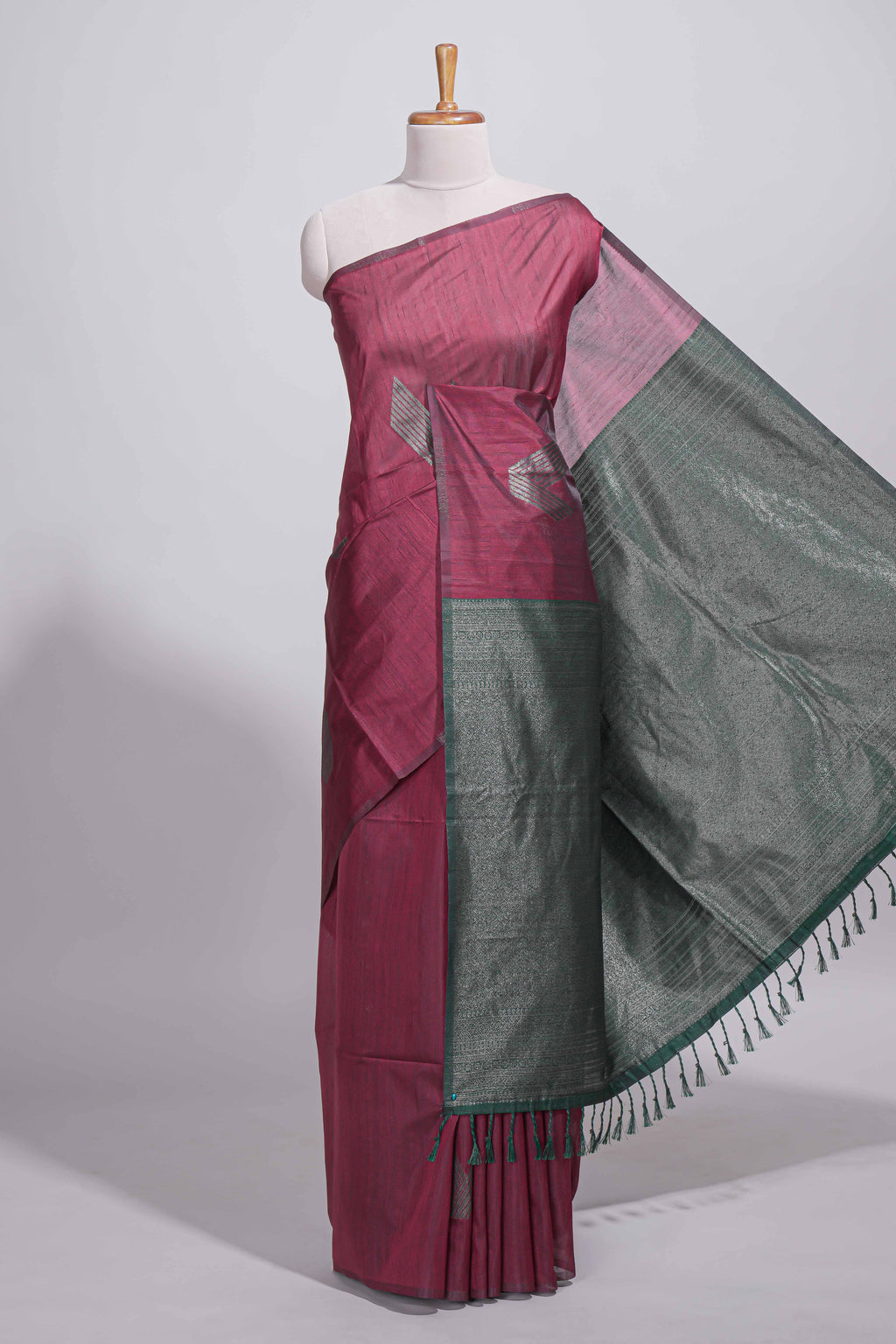 Maroon tussar saree with subtle silver woven motifs paired with a rich zari pallu with tassels with contrast blouse piece