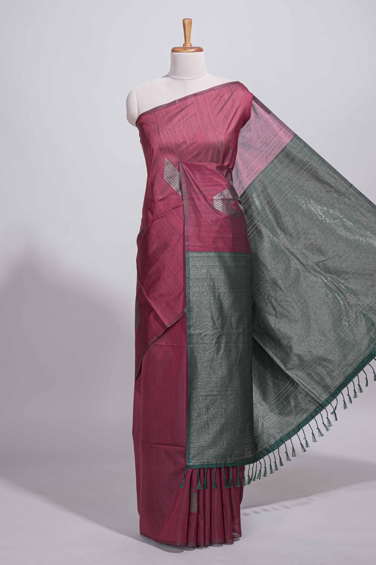 Maroon tussar saree with subtle silver woven motifs paired with a rich zari pallu with tassels with contrast blouse piece
