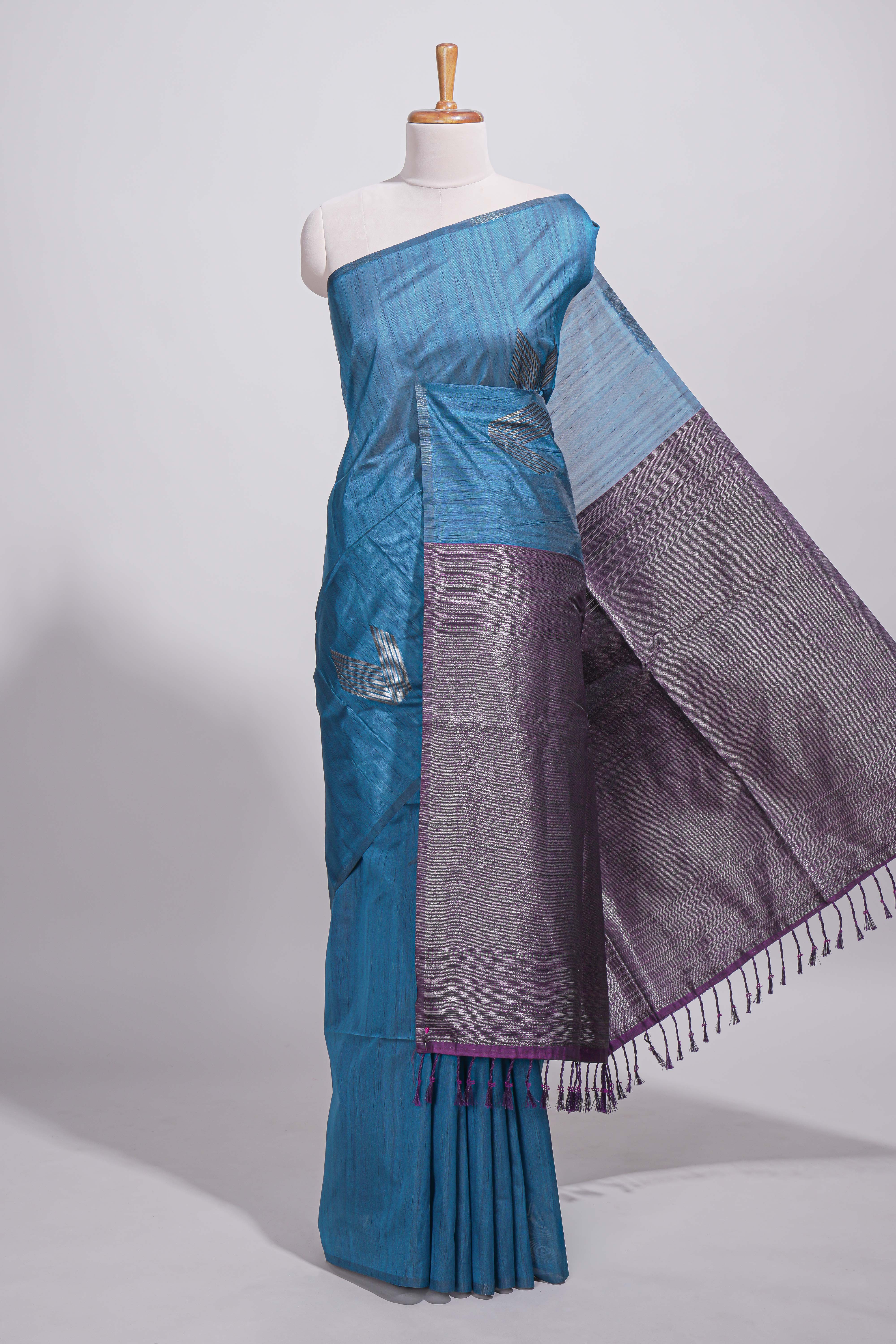 Royal blue tussar saree with subtle silver woven motifs paired with a rich zari pallu with tassels with contrast blouse piece
