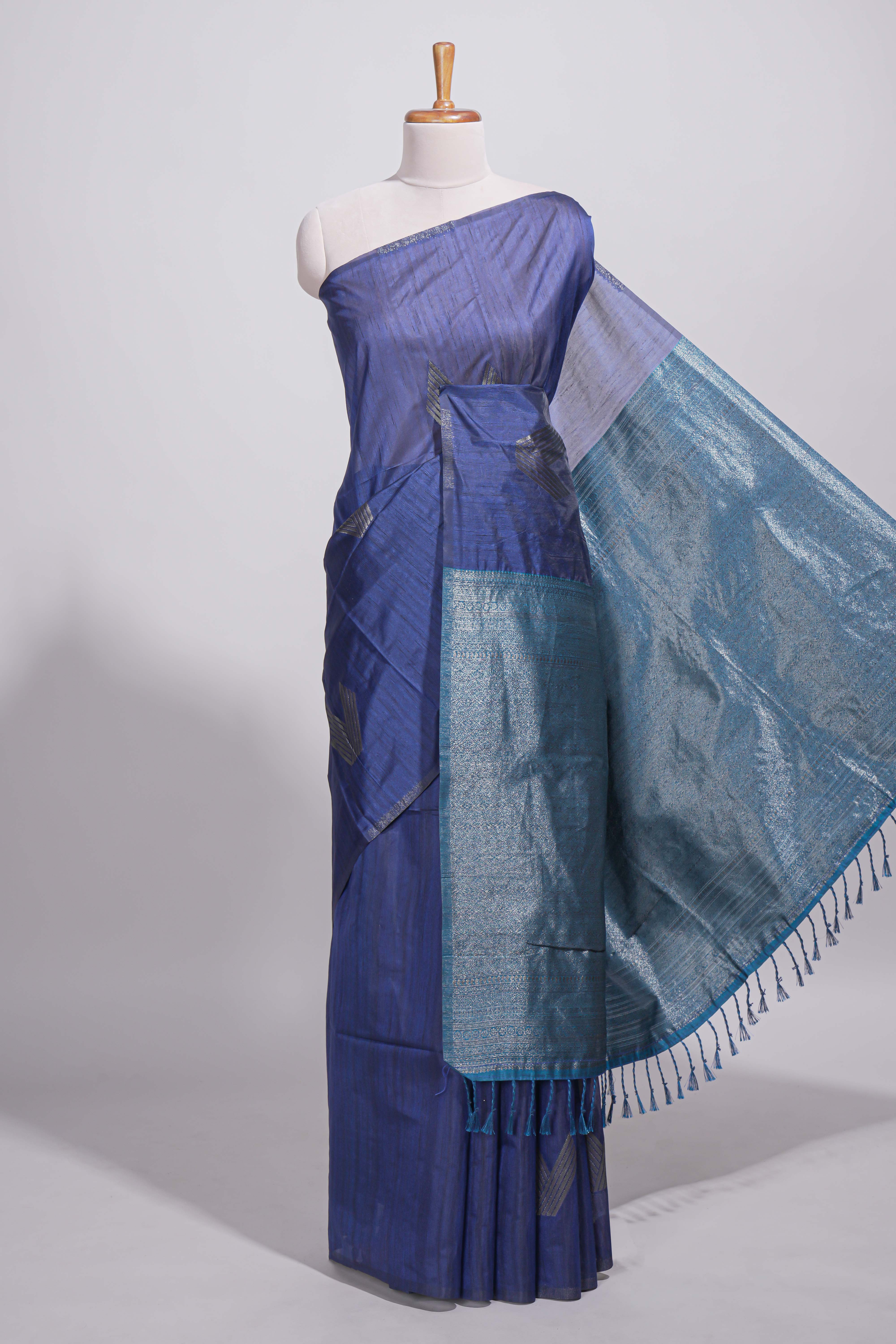 Navy blue tussar saree with subtle silver woven motifs paired with a rich zari pallu with tassels with contrast blouse piece