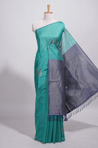 Peacock green tussar saree with subtle silver woven motifs paired with a rich zari pallu with tassels with contrast blouse piece