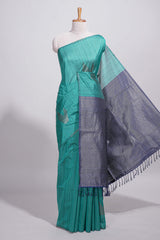 Peacock green tussar saree with subtle silver woven motifs paired with a rich zari pallu with tassels with contrast blouse piece