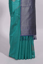 Peacock green tussar saree with subtle silver woven motifs paired with a rich zari pallu with tassels with contrast blouse piece