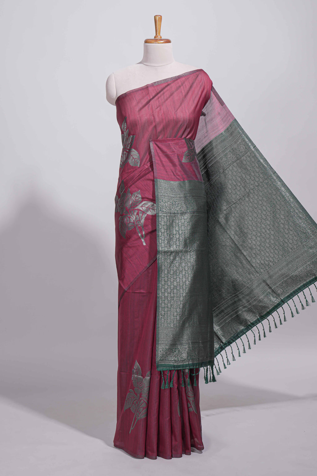 Dark maroon color tussar saree with subtle silver woven motifs paired with a rich zari pallu with tassels with contrast blouse piece