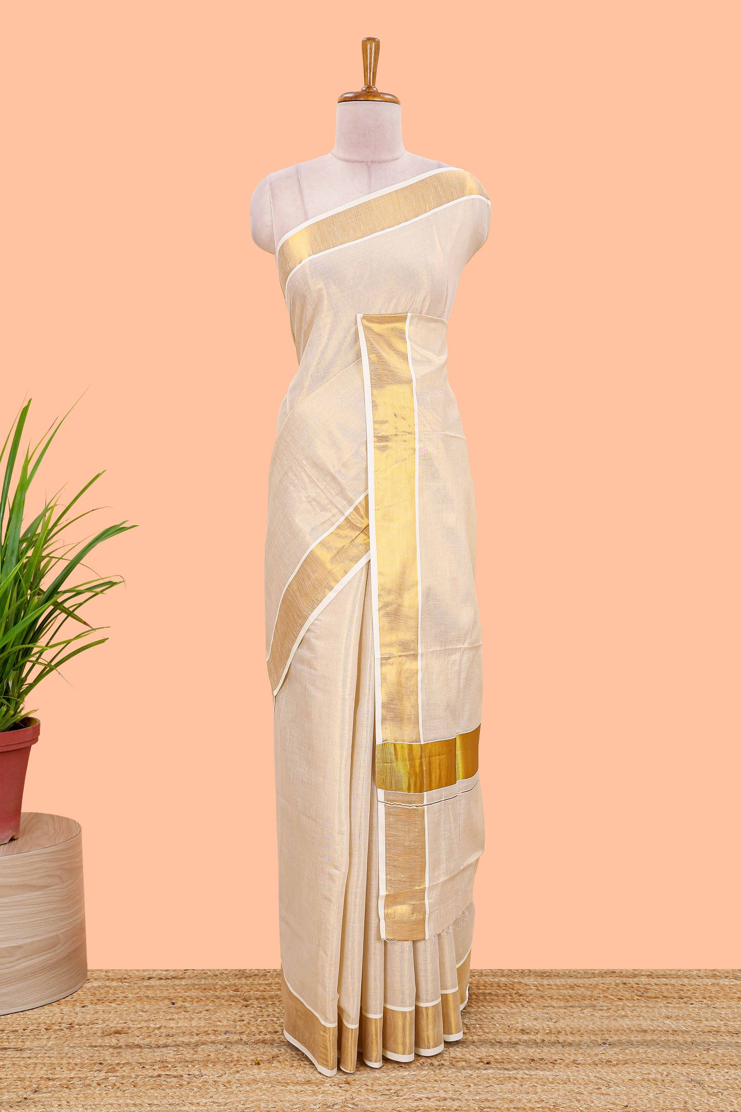 Cream kerala tissue saree featuring a plain body and traditional gold jari border