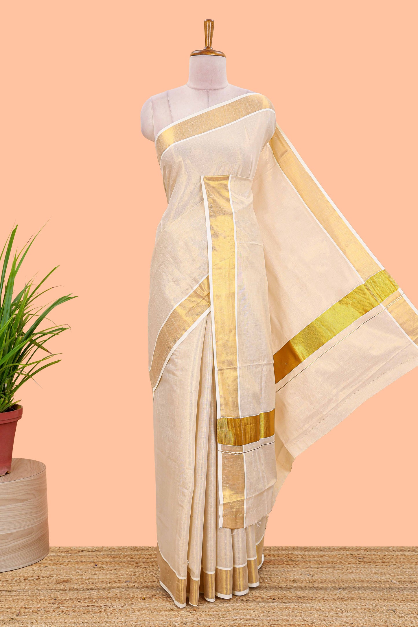 Cream kerala tissue saree featuring a plain body and traditional gold jari border