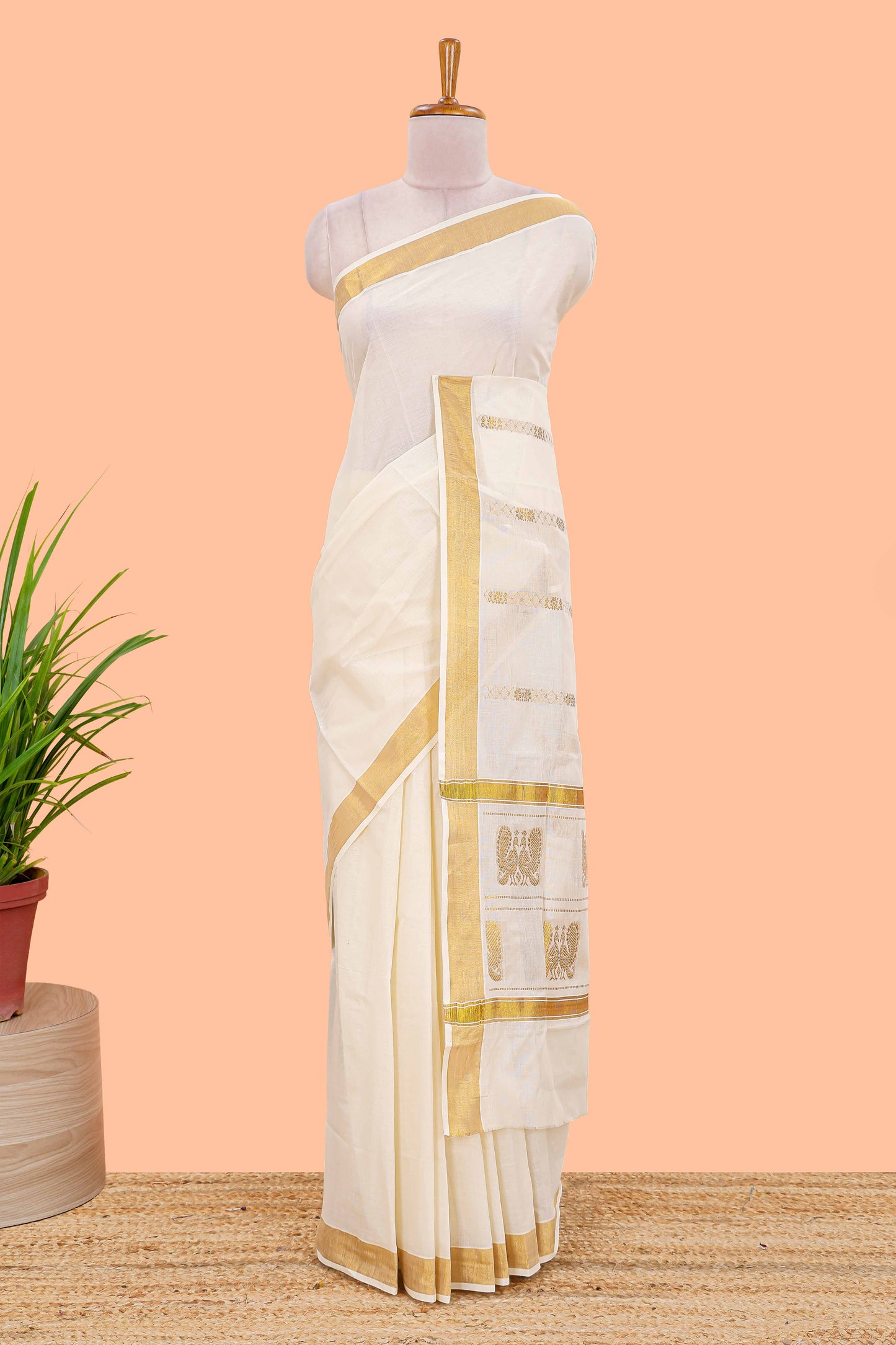 Cream kerala cotton saree with rich peacock design pallu and gold jari lines