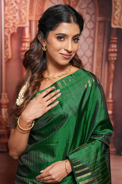 Borderless green parambariya pattu saree with zari stripes and matching checked zari pallu