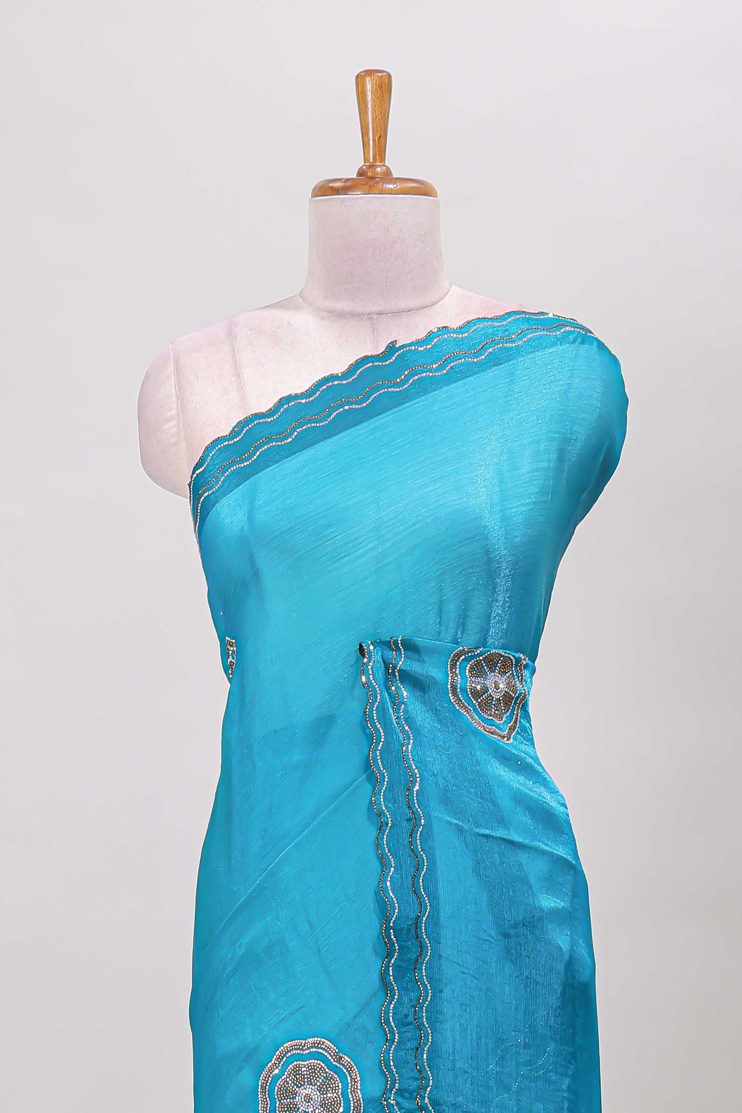 Blue floral stone work motifs semi chiffon saree with self scallop border and matching blouse