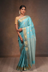 Turquoise blue art silk saree with gold zari woven circular motifs fine vertical zari lines and a rich traditional zari border with woven pallu along with matching blouse